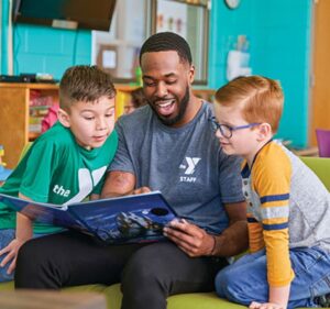 staff member reads to two children