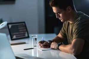 Military service member writing to family during deployment