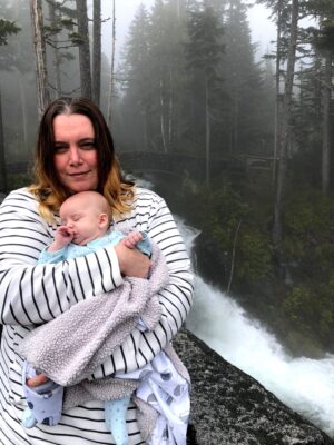 Military spouse and mom Julianna holds her newborn during a Mt. Rainier Hike
