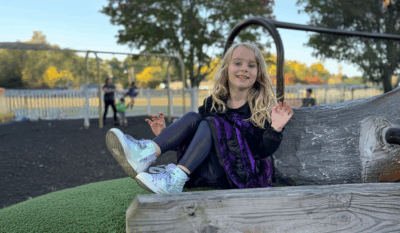 Military child smiling in front of her new school