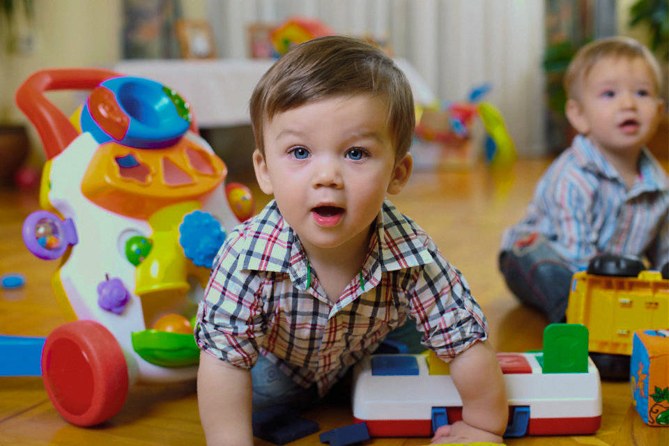 Babies play with colorful toys in a colorful classroom