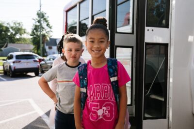 Military kids in front of school bus ready for their new school