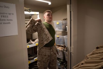 Military service member trying on uniform at an ASYMCA branch