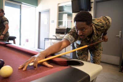 Military service member playing pool at an ASYMCA branch