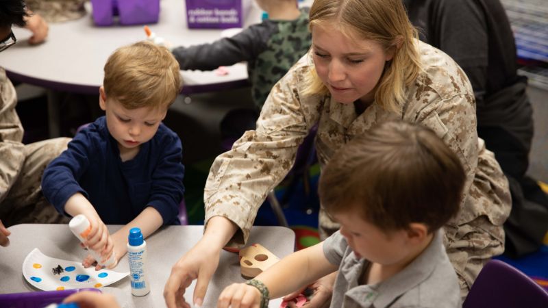 military parent helps son with a craft project during operation little learner