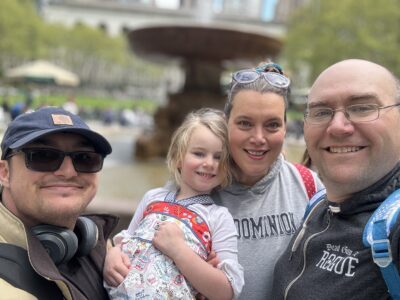 Military family smiling outdoors in front of a fountain