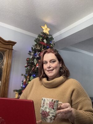 Military spouse writer Julianna smiling with Christmas tree in the background