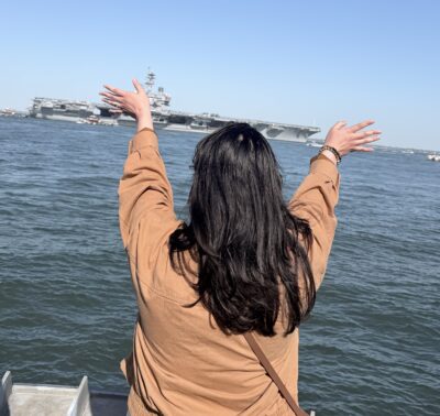 Military spouse waving goodbye to her husband's ship.