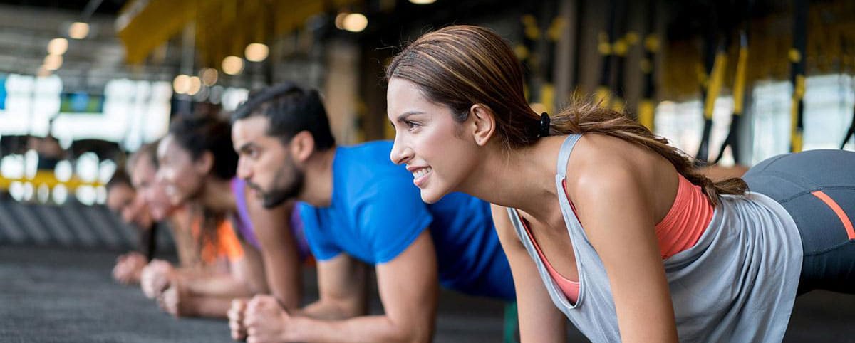 A class holds the plank position in a fitness studio