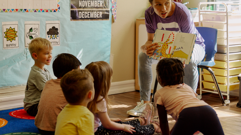 An Armed Services YMCA early education teacher reads to young children