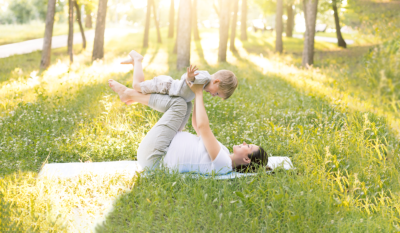 Military spouse playing with her baby in the grass.