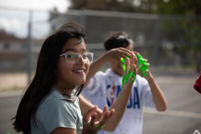 Young military daughter playing with slime.