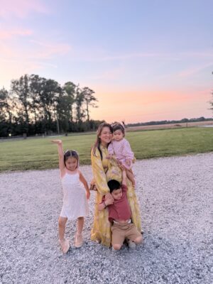 Military spouse enjoying a sunset with her three young kids.