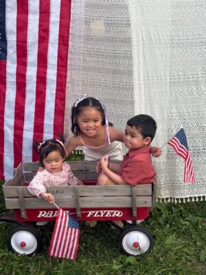 Three military children posing with American flags.
